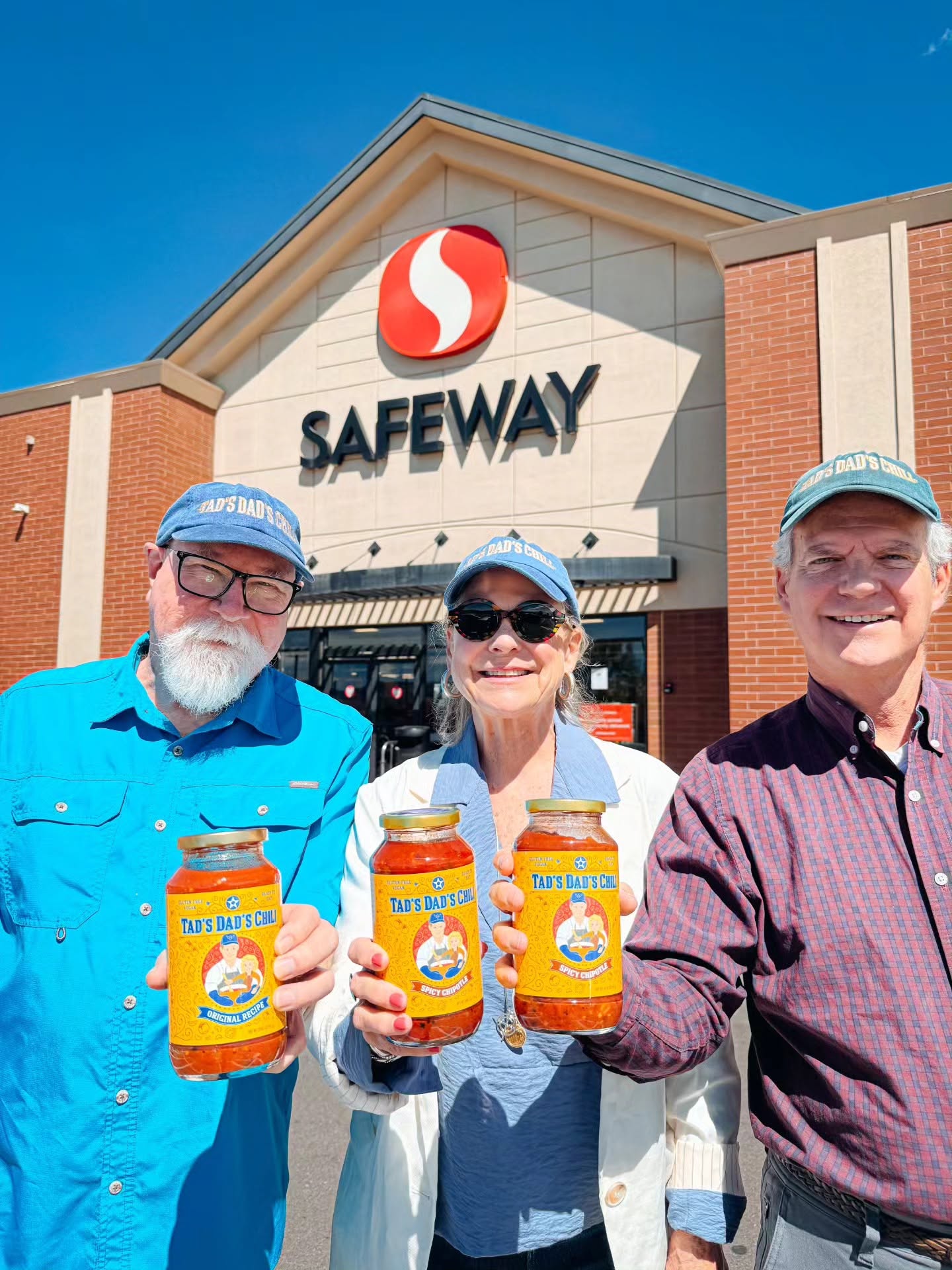 gary, tad and john holding a tad's dad's chili jar each in front of a safeway store